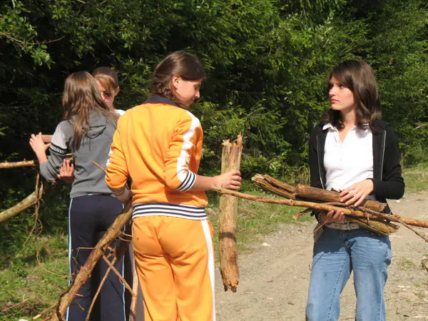 Fete cărând lemne de foc pe un drum forestier