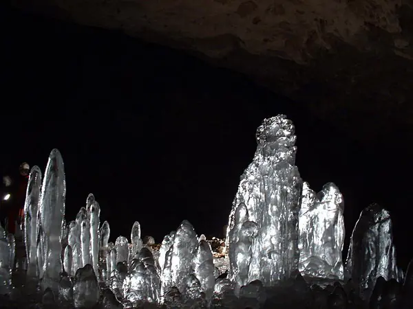 Prim-plan cu stalagmite de gheață transparente, strălucind într-o peșteră