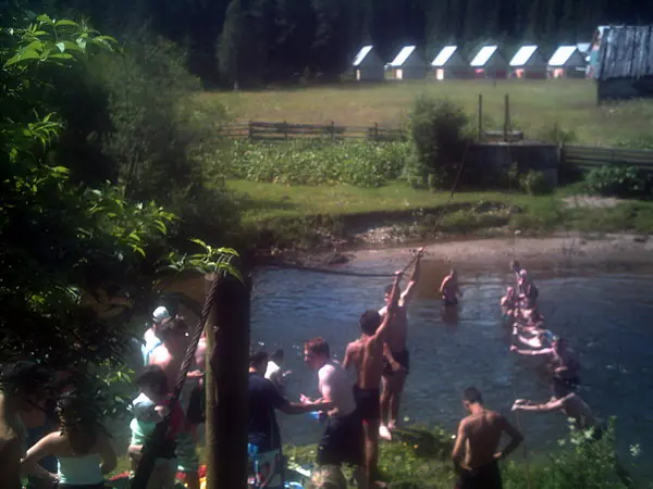 Tabărăși făcând baie într-un pârâu de munte, într-o zi însorită