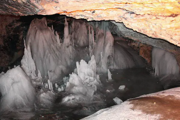 Grup de stalagmite de gheață sub tavanul de stâncă al Peșterii Ghețarul Scărișoara