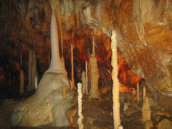 Coloane înalte de stalagmite albe într-o sală a Peșterii Urșilor