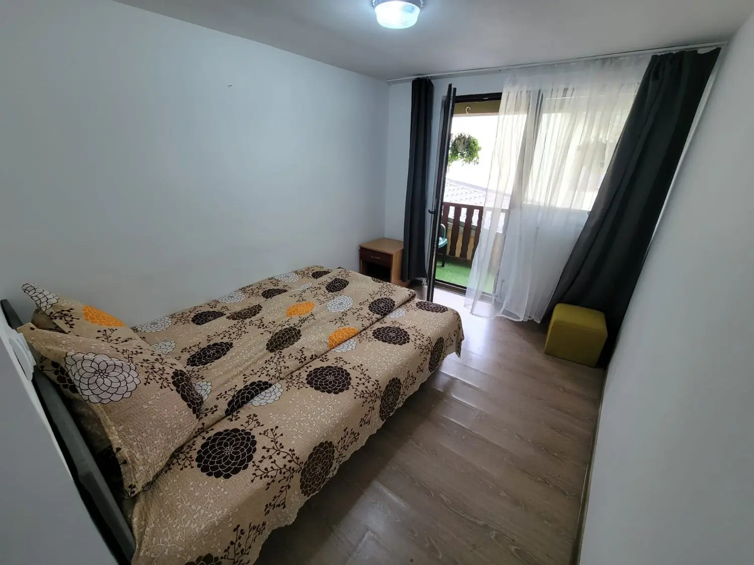 Cameră dublă cu lenjerie cu model și ușă spre balcon cu perdele