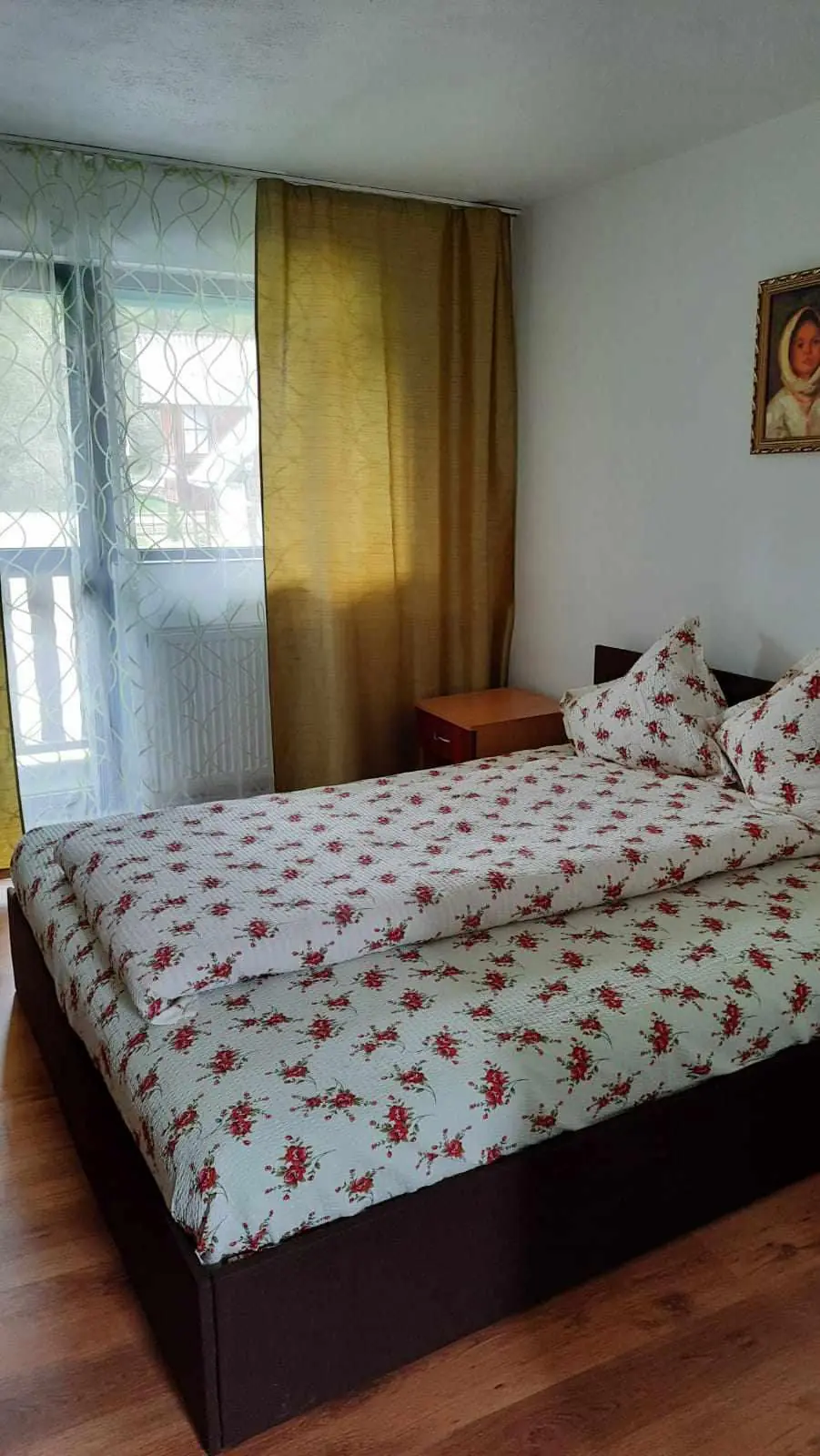 Cameră dublă cu lenjerie cu flori și fereastră spre balcon