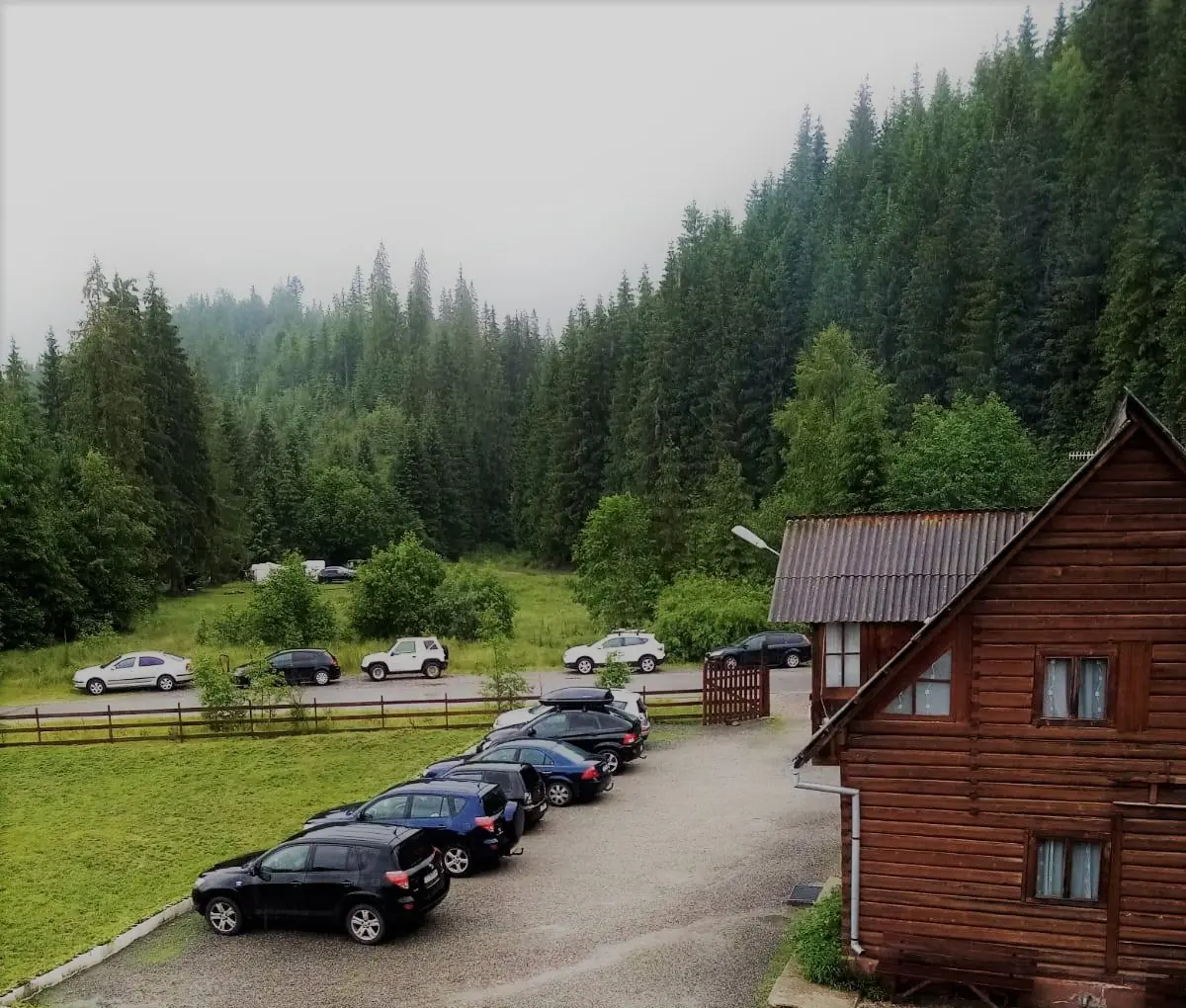 Vila Ioana și parcarea ei văzute de sus, înconjurate de pădure de brazi