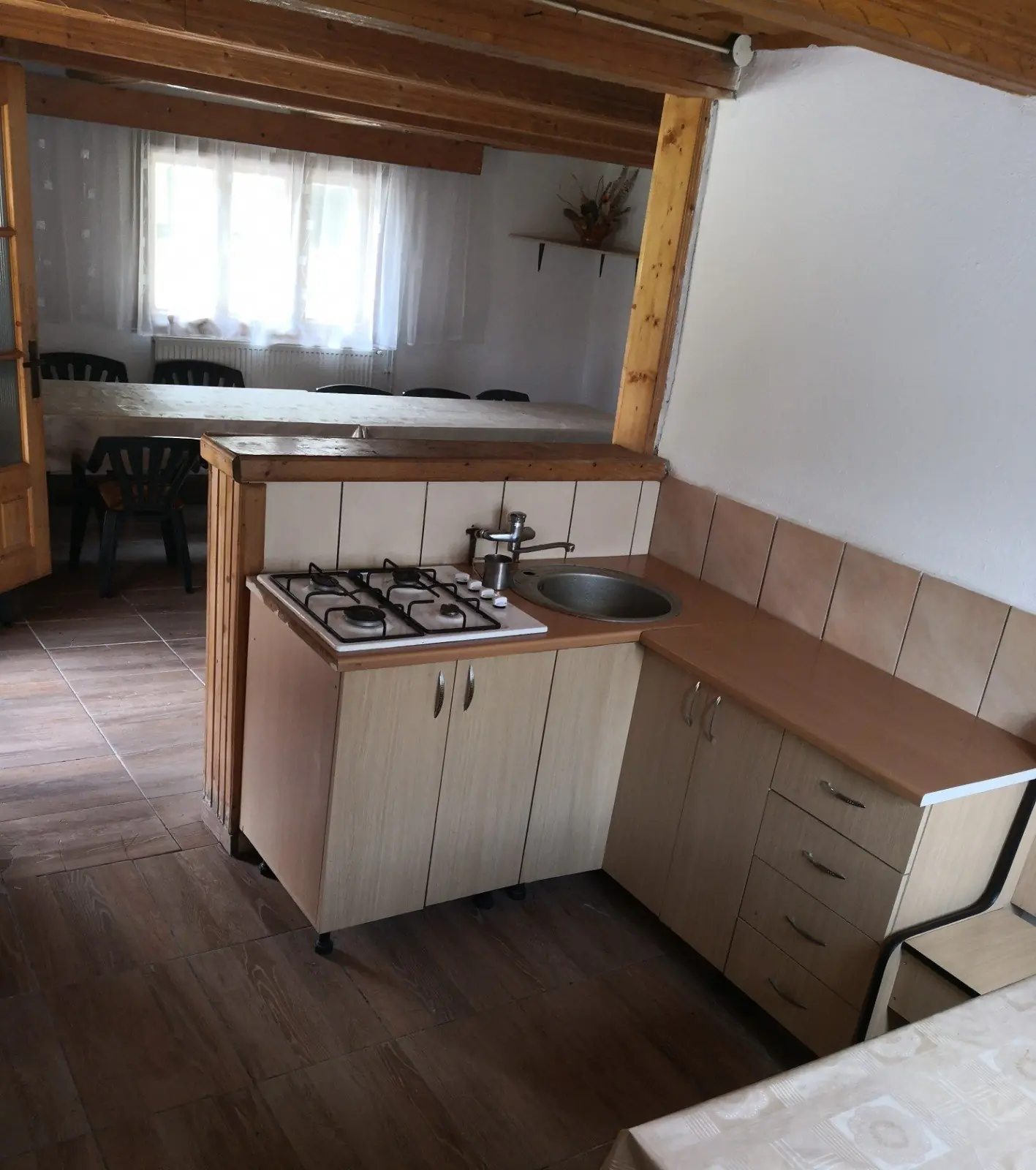 Chicinetă cu aragaz, chiuvetă și dulapuri, lângă zona de luat masa