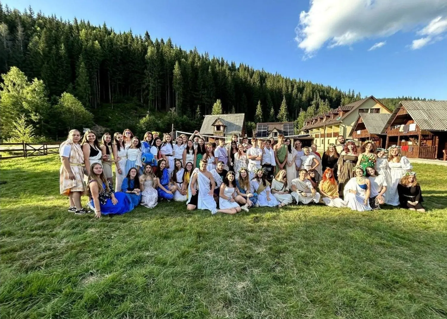Grup mare de tabără la Ic Ponor, pozând pe pajiște în fața pădurii