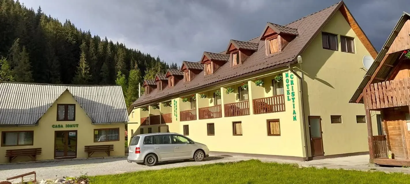 Motelul Cristian & Denisa, clădire galbenă cu balcoane din lemn