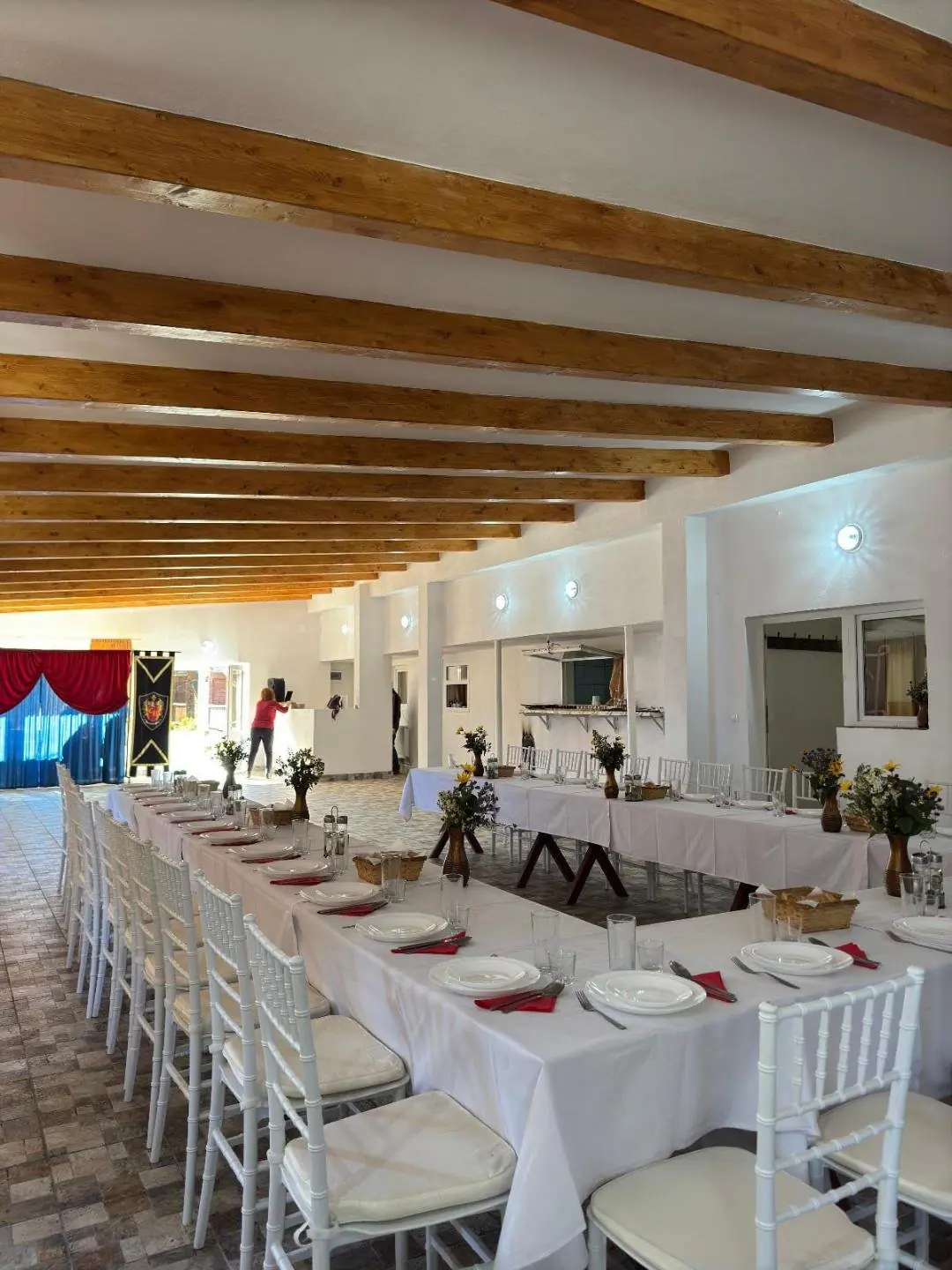 Sala restaurantului cu mese lungi pregătite pentru un eveniment